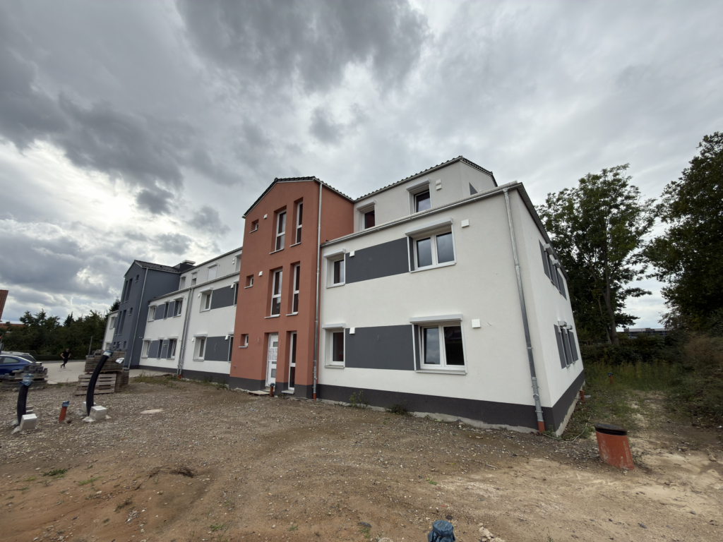 Baustellenaufnahme des Mehrfamilienhauses mit 8 Wohneinheiten in Lindhorst – Außenfassade weitgehend fertiggestellt, Außenanlagen noch in Ausführung.
