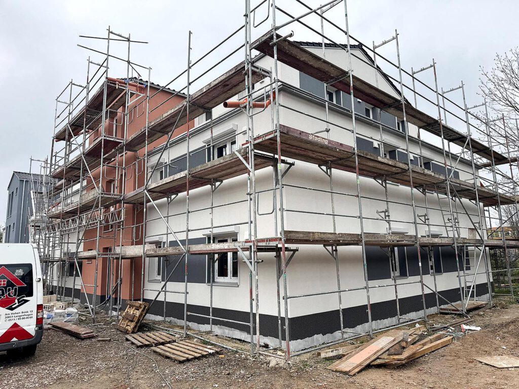 Neubau Grüner Weg Lindhorst im Bauzustand mit fertiggestelltem Farbanstrich der Außenfassade in Weiß, Anthrazit und Bordeauxrot, Baufortschritt 2. Bauabschnitt