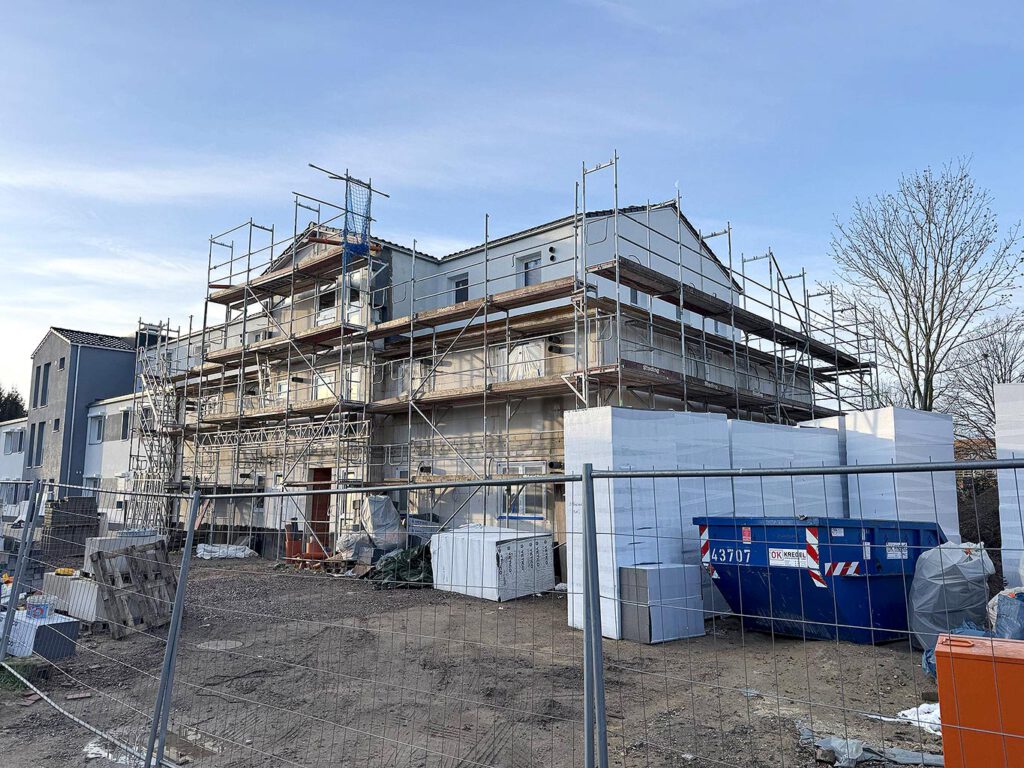 Neubau Grüner Weg Lindhorst im Bauzustand mit Gerüst, Oberputzarbeiten am Staffelgeschoss, Baufortschritt 2. Bauabschnitt