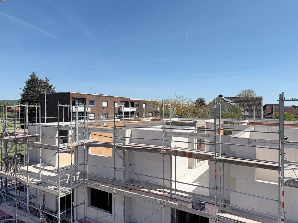 Rohbauphase des Mehrfamilienhauses am Zum Rehmer Eck in Bad Oeynhausen – Blick über die Massivbaukonstruktion mit Gerüst, Baustart 2026, Fertigstellung Ende 2027.