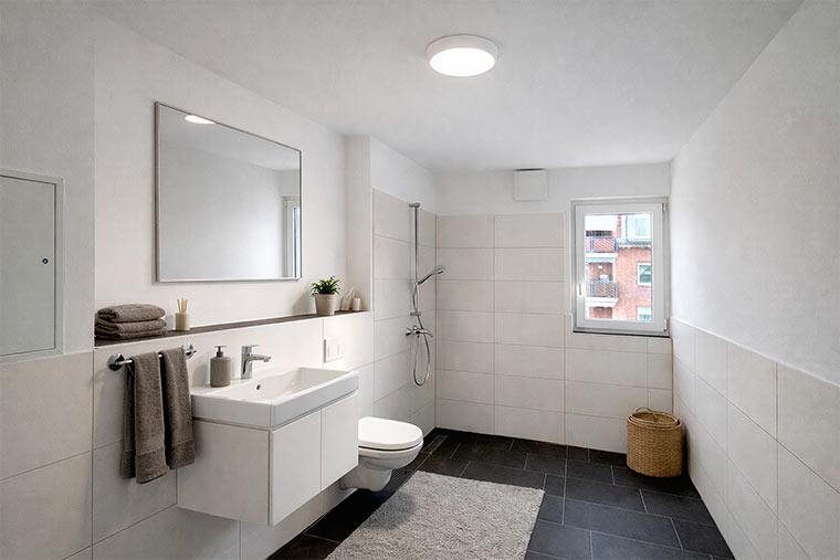 Helles, modernes Badezimmer einer Neubauwohnung in Lindhorst mit großformatigen Fliesen und bodengleicher Dusche